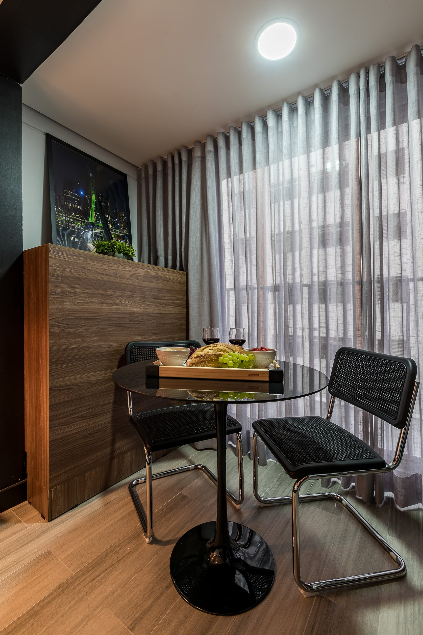 Mesa de refeições para dois junto à cortina, com bandeja servida