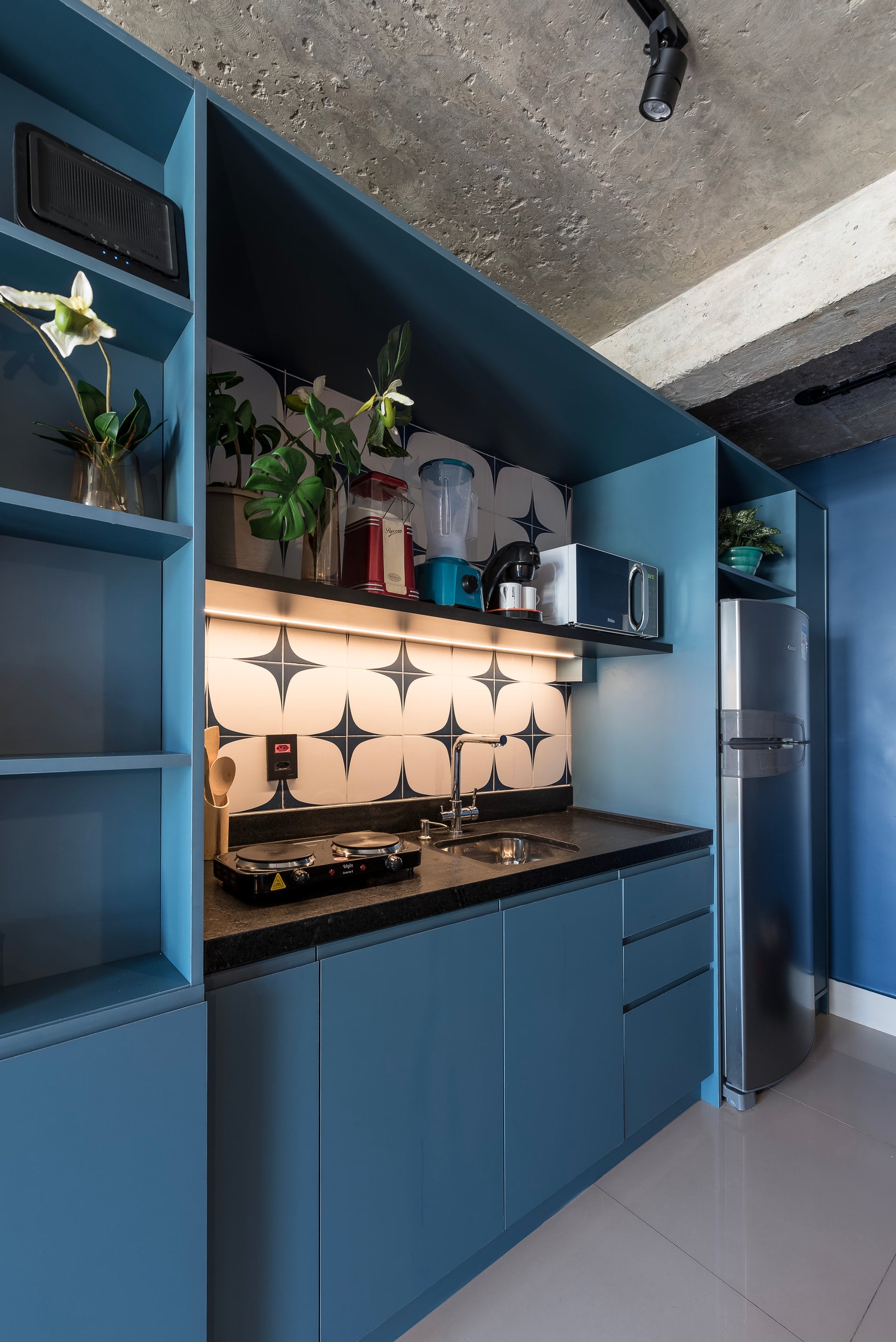 Detalhe da bancada da cozinha com azulejo geométrico e cooktop