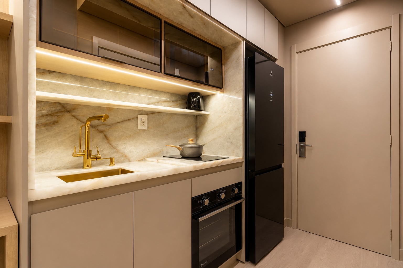 Cozinha compacta com bancada de mármore, cooktop e forno embutido