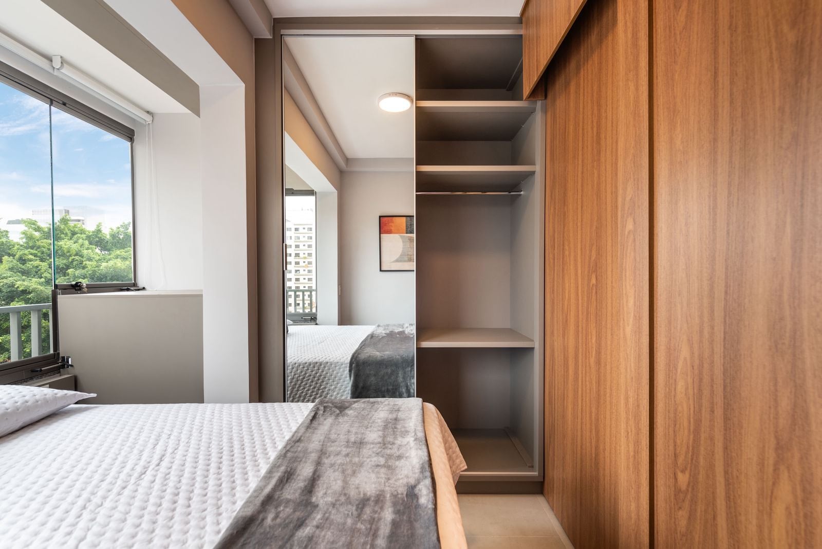 Dormitório com marcenaria, closet aberto e cama de casal